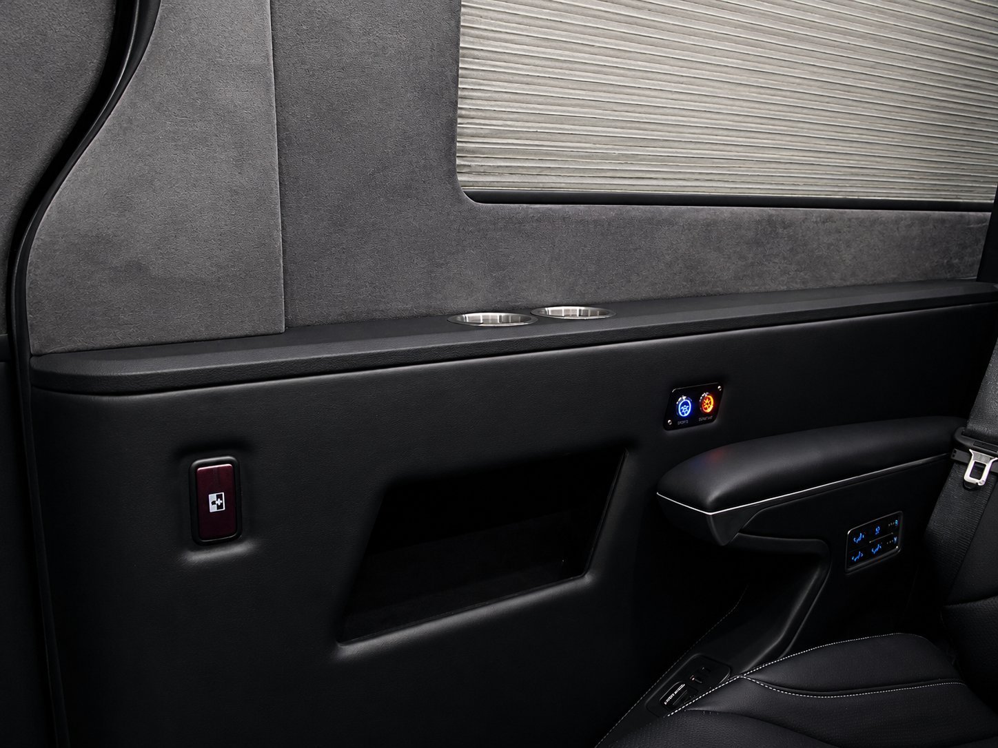Car door interior panel with gray fabric upholstery, black trim, window controls, and indicator lights
